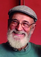 Enrique Martínez Lozano sonriendo con gorra y barba blanca