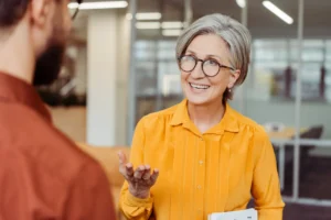 Mujer mayor sonriente conversando en un entorno profesional
