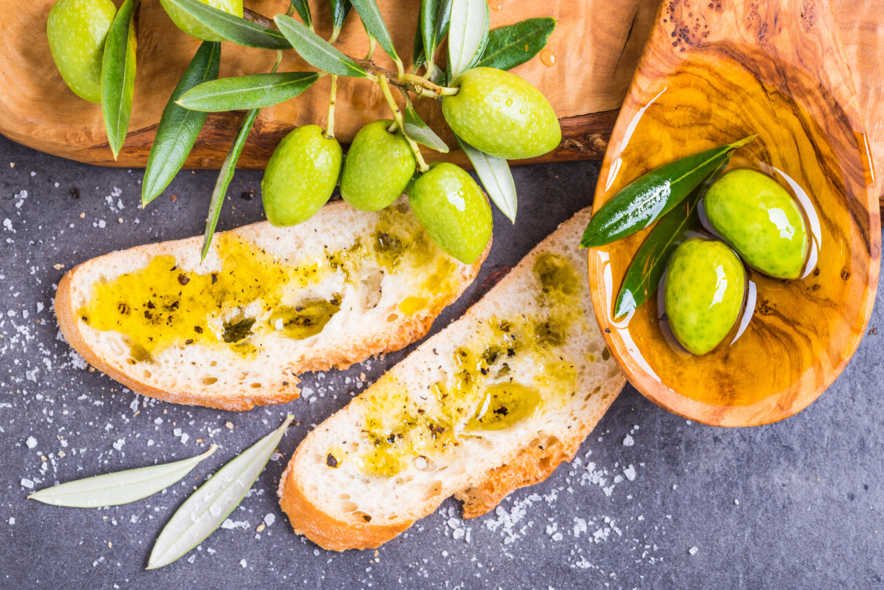 Rebanadas de pan con aceite de oliva y aceitunas verdes