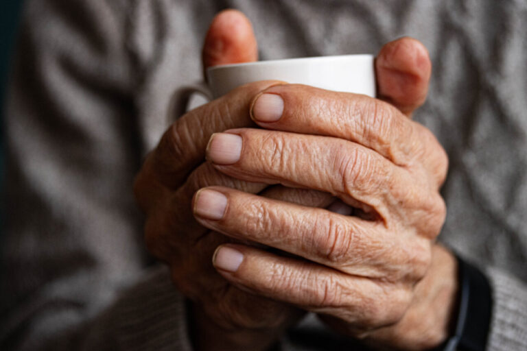 Persona con temblor en las manos sosteniendo una taza