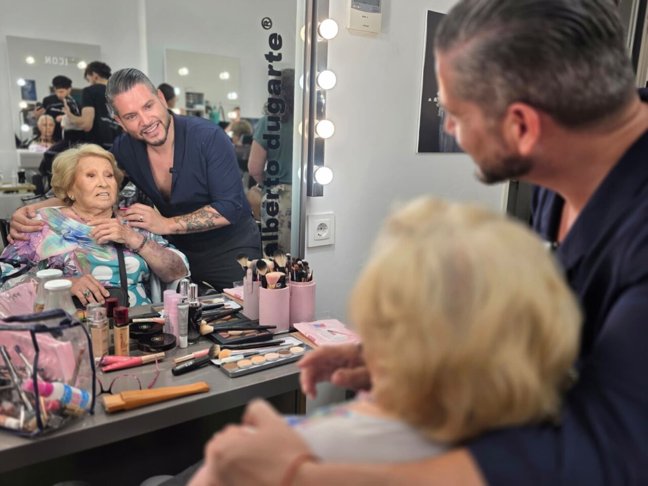Maquillador Alberto Dugarte aplicando maquillaje a una mujer mayor