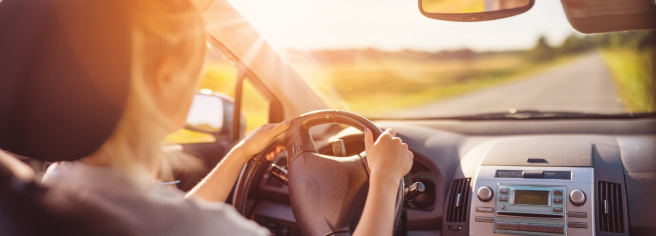 Conductor al volante bajo la luz del sol, mostrando preocupación por medicamentos